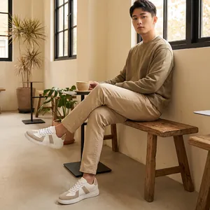 Mannelijk model met beige German Army Trainer sneakers in een gezellige café-omgeving