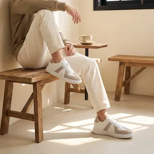 Lifestyle-weergave van wit en beige Duitse legersneakers gedragen in een gezellig café