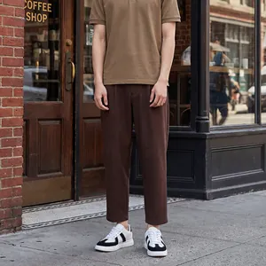 Detailopname van zwart-witte GAT-sneakers gedragen met een bruine broek in de stad