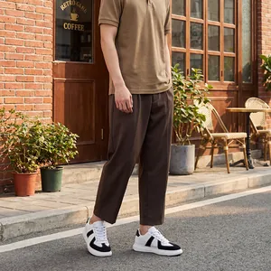 Man die zwart-witte German Army Trainer-sneakers draagt in een straatomgeving buiten