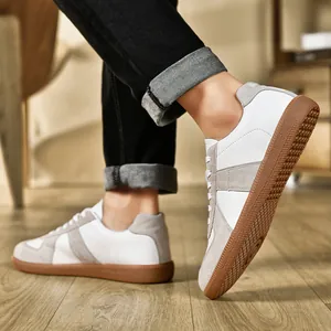Vista laterale delle sneakers GAT retrò con pelle bianca, camoscio grigio e suola in gomma