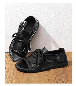 Gedetailleerde foto van zwarte herensandalen met dikke touwveters op houten vloer.