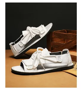 Detailopname van witte casual herensandalen met dikke touwveters en een zwarte zool
