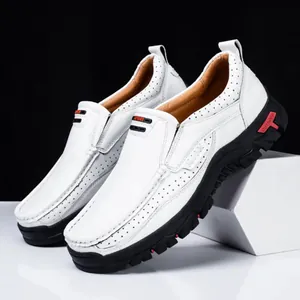 Macro view of breathable white leather loafers for men featuring rugged black soles.