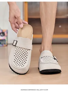 Detailaufnahme beiger Herren-Clogs mit Laserschnitt-Löchern und Schnallenriemen