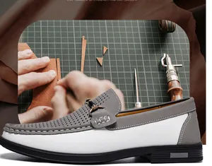 Close-up detail of handcrafted men's perforated leather loafers with metal buckle