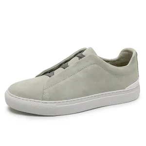 Scarpe casual da uomo in pelle scamosciata grigia con elastici e suola in gomma bianca.