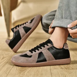 Primo piano di sneakers GAT retrò in pelle scamosciata nera e grigia con suola in gomma.