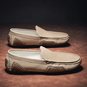 Vista lateral detallada de mocasines de cuero beige para hombre con tacos.