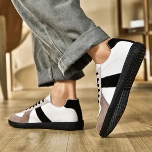Vista laterale delle sneakers retrò German Army Trainer indossate con jeans su legno