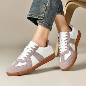 Primo piano di scarpe De-schun bianche e grigie indossate con jeans in denim.