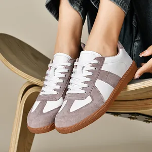 Primo piano di scarpe da ginnastica rétro German Army Trainers bianche e grigie con suola