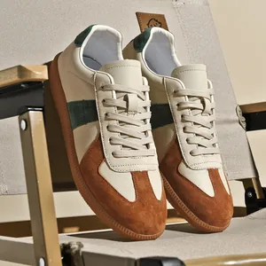 Sneaker GAT vintage in pelle color crema e camoscio marrone su una sedia da campeggio