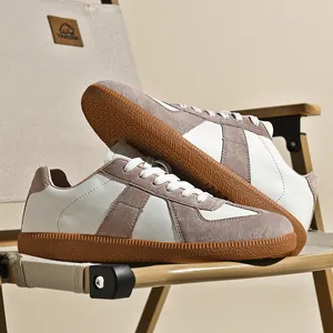 Primo piano delle sneakers retrò German Army Trainer in pelle bianca e camoscio marrone