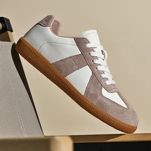 Dettaglio scarpe GAT retrò bianche e taupe in pelle scamosciata e suola gomma