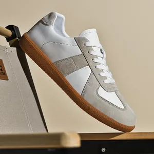Vista laterale dettagliata di sneaker retrò bianche German Army Trainer con suola in gomma