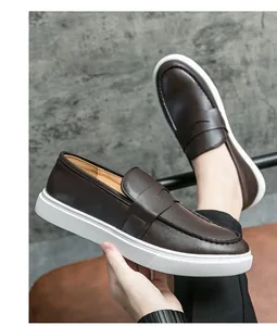 Detalle de los mocasines de cuero marrón oscuro para hombre con suela de goma blanca gruesa.