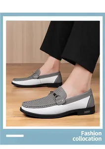 Detail of perforated grey and white leather loafers with metal buckle for men