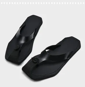 Detail von schwarzen Vintage-Flip-Flops für Herren mit weicher Sohle und Knotendesign.