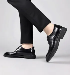 Scarpe stringate Derby professionali in pelle nera mostrate di profilo da uomo