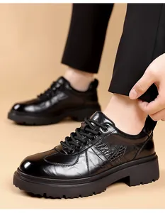 Detailed close-up of black crocodile-embossed leather Derby shoes with chunky lug soles.