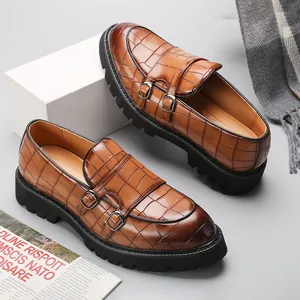 Brown crocodile patterned men's monk strap loafers with thick black soles in British style.