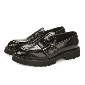 Black men's monk strap loafers with crocodile pattern and thick lug sole in British style.
