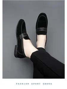 Elegant macro view of men's black suede penny loafers worn for business attire