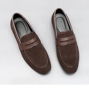 Overhead view of elegant dark brown suede men's loafers featuring leather saddle detail