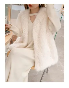 Dettaglio macro dell'elegante gilet in pelliccia sintetica bianco crema su un abito