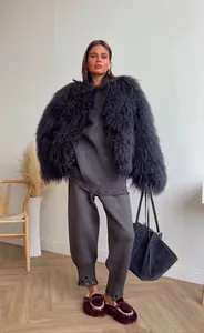 Dettaglio del cappotto in ecopelliccia grigio scuro abbinato a pantaloni in maglia