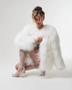 Close-up view of a luxury white shaggy faux fur coat for elegant winter party fashion
