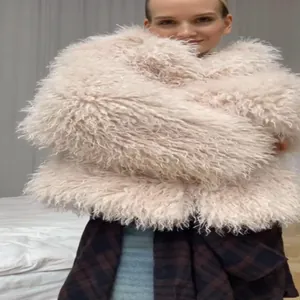 Close-up detail of a fluffy light pink faux fur coat showing the soft texture on a model