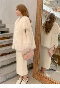 Donna elegante con gilet in ecopelliccia bianco crema con scollo a V e gonna lunga abbinata