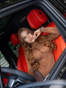 Detail eines Models im braunen gerippten Rollkragen-Oberteil in einem Auto mit Ledersitzen.