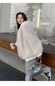 Stylische beige Oversized-Kunstpelzjacke mit Kapuze für Damen im modernen Außenbereich.