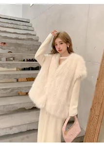 Dettaglio elegante di un gilet in ecopelliccia crema media lunghezza con scollo a V donna