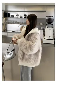Asiatisches Model trägt eine stylische cremefarbene Webpelzjacke mit Kapuze im Café