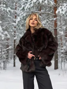 Detailaufnahme einer luxuriösen dunkelbraunen Pelzjacke aus Fuchsimitat in einer Schneelandschaft