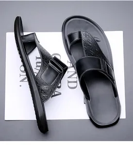 Detailweergave van zwarte lederen teenslippers voor heren met reliëfpatroon en stiksels