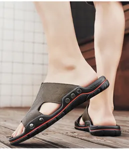 Close-up van bruine herensandalen van leer met antislipzolen op houten dek