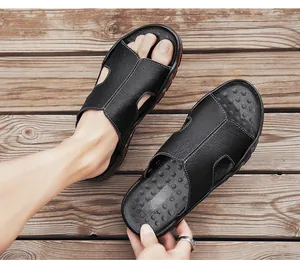 Gedetailleerd overzicht van zwarte leren herensandalen met antislip getextureerd voetbed