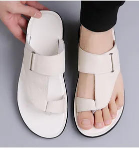 Gedetailleerde close-up van heren teenslippers van echt rundleer in een beige kleur.