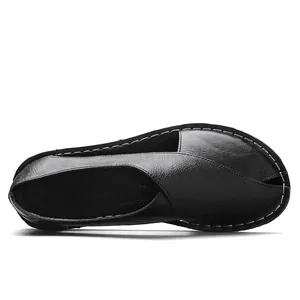 Top view of a handmade black soft sole retro hollow flat sandal with side cutouts.