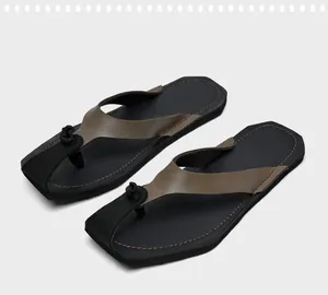 Detailansicht der Retro-Flip-Flops für Herren mit braunen Lederriemen und schwarzer Sohle