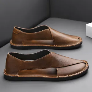 Close-up of brown vintage hollow-out leather loafers with handmade stitching details.