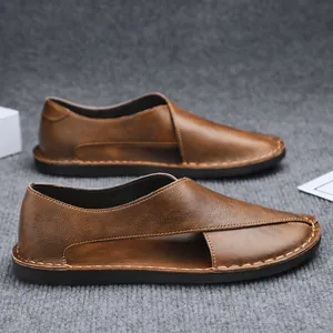 Detailed side view of brown handmade vintage hollow slip-on sandals with stitching