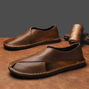 Close-up of brown handmade leather slip-on sandals with hollow retro design