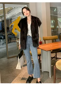 Elegante gilet lungo in ecopelliccia marrone scuro indossato in un bar