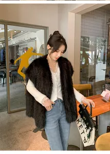 Dettaglio di un elegante gilet in ecopelliccia nera indossato in un bar moderno